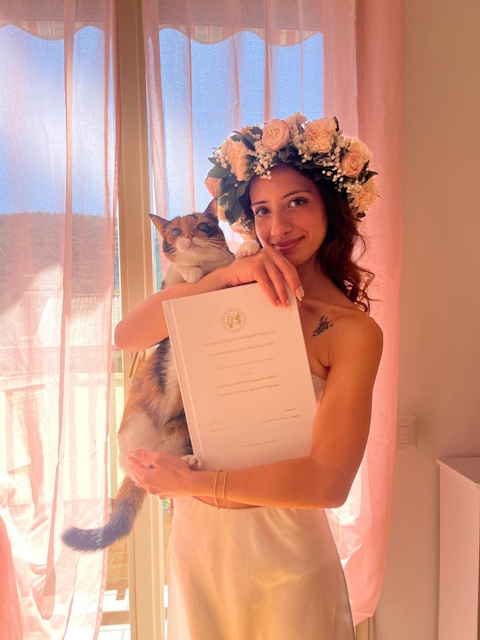La Dott.ssa Elisa Malacasa con la corona d'alloro e un gatto in braccio